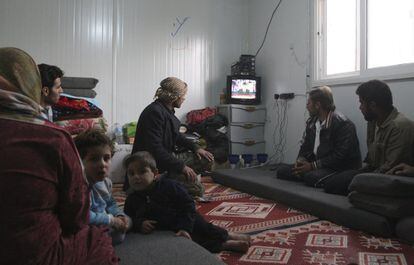 Una familia de refugiados miran en la televisión un discurso del presidente sirio Bashar El Assad, en enero de 2013.