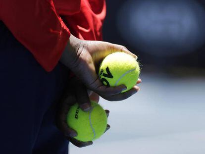 Un recogepelotas sujeta dos bolas durante un partido en Melbourne.