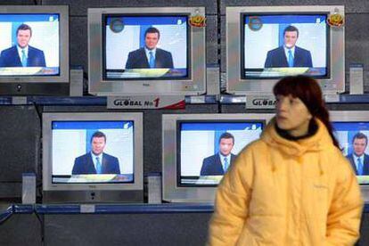 Una mujer sigue el debate entre los candidatos a la presidencia de Ucrania en una tienda de televisores de Kiev.