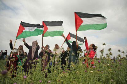 Fuentes militares informaron a EFE de que unos 200 palestinos han participado ya en protestas violentas en cuatro localidades a lo largo de la valla de seguridad que separa Gaza de Israel, encendiendo hogueras y lanzando piedras a los soldados israelíes. En la imagen, mujeres palestinas agitan banderas cerca de la frontera con Israel, el 30 de marzo.