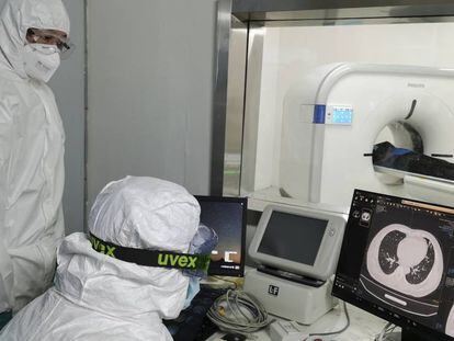 Dos médicos realizan una prueba a un paciente afectado por coronavirus en un hospital temporal construido en Wuhan (China). En vídeo, las imágenes de los enfermos en China.