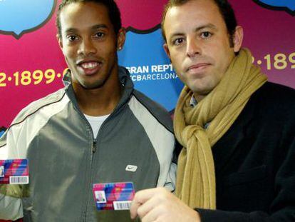 Ronaldinho y Sandro Rosell con el carnet de socio del F.C. Barcelona. 