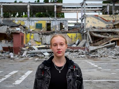 Mariia, de 12 años, en Járkov en agosto. La escuela a la que iba a asistir este curso (al fondo) fue parcialmente destruida en un bombardeo.