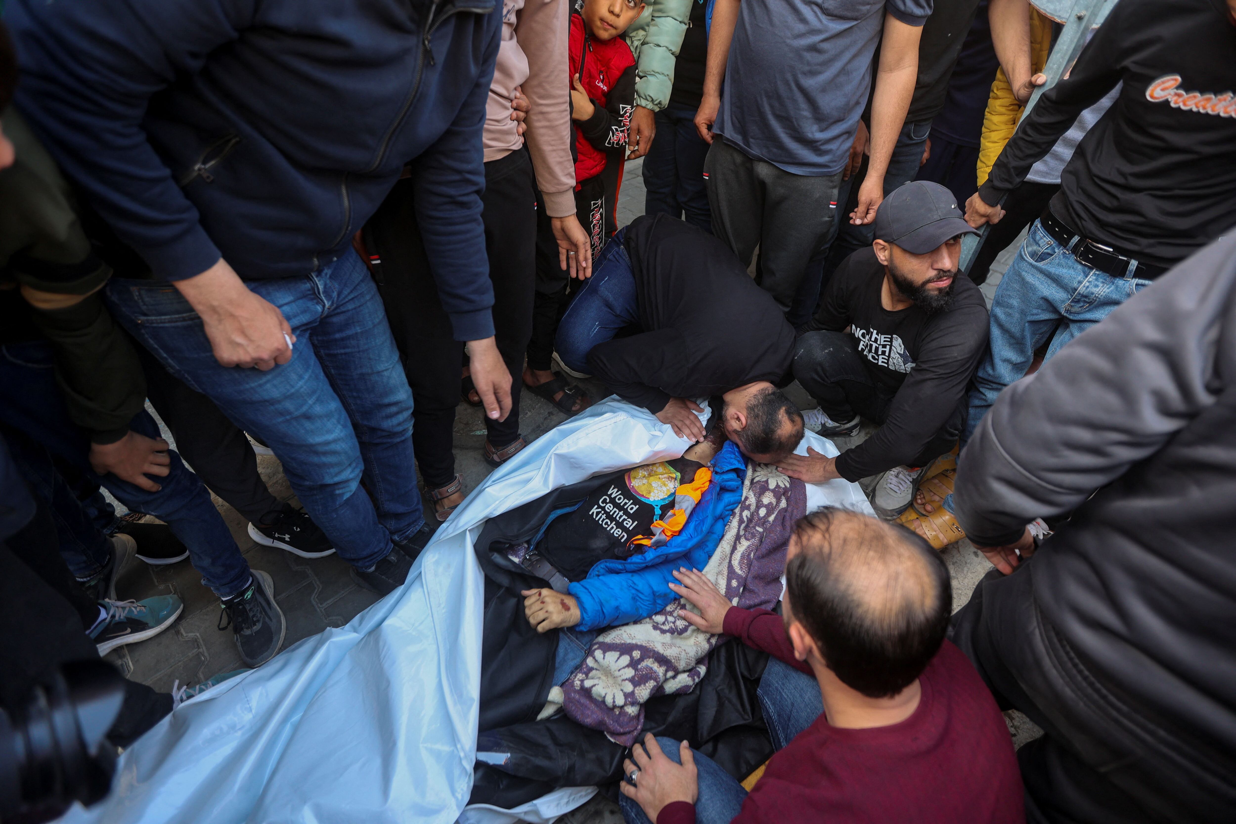 Varias personas se lamentan alrededor del cuerpo del palestino Issam Abu Taha, uno de los trabajadores de World Central Kitchen que ha muerto este martes a causa de un ataque israelí, al sur de la Franja.