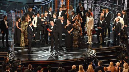 Los equipos de las películas 'La La Land' y 'Moonlight', en el escenario tras anunciarse que la película ganadora no es el musical del director Damien Chazelle, sino el drama dirigido por Barry Jenkins. En el centro de la imagen, Warren Beatty, con el sobre en la mano.
