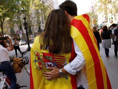 Uns amics assisteixen a la protesta de Barcelona amb les banderes espanyola i catalana.