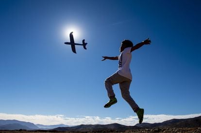 Un niño juega con un avión en el desierto de Atacama, desde donde se ha visto el eclipse.