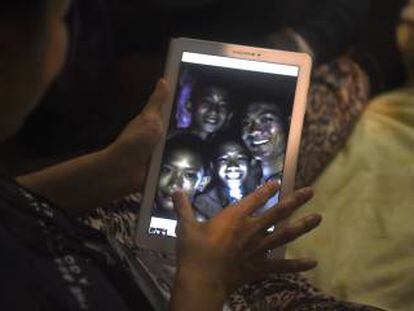 Familiares observan a través de un dispositivo electrónico a los niños atrapados en una cueva en Tailandia.