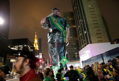 Los partidarios de Jair Bolsonaro sostienen una figura gigante que representa al candidato de Bolsonaro para la vicepresidencia, Hamilton Mourao, en la noche electoral.