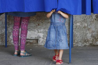 Una mujer acompañada de una niña vota durante la jornada de elecciones presidenciales en Chile.