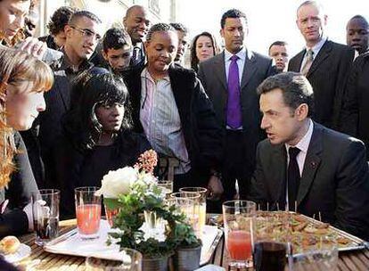 Nicolas Sarkozy charla con representantes de barrios marginales de Francia, ayer en París.