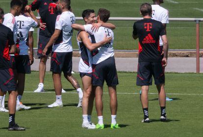 Robert Lewandowski se despide de Thomas Müller en el entrenamiento del Bayern, este sábado.