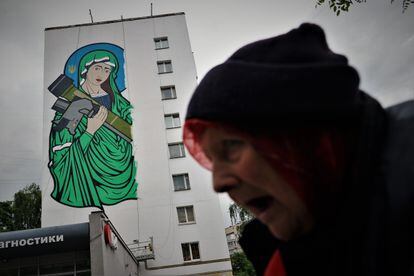 Una mujer pasa delante del mural de Santa Javelina en Kiev