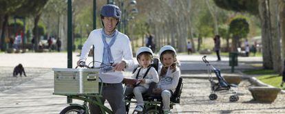 El padre ciclista, Oliver Green, pasea a sus hijas por Pozuelo.