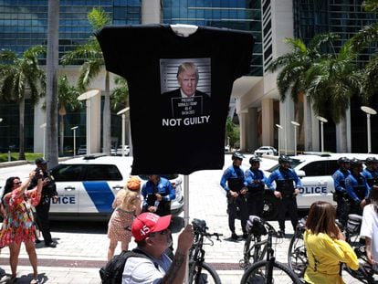 Un partidario de Donald Trump sujeta una camiseta con la efigie del expresidente sobre la que se lee "No culpable", en el exterior del juzgado de Miami donde comparece el exmandatario, este martes.