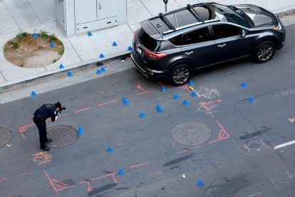 A police expert takes a photograph in the area of ​​the shooting that left six dead.