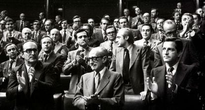 El presidente del Gobierno, Adolfo Suárez (derecha), y los vicepresidentes Enrique Fuentes Quintana (izquierda) y el teniente general Manuel Gutiérrez Mellado, aplauden en pie desde sus escaños en el Congreso tras la aprobación de la Ley de Amnistía, el 14 de octubre de 1977.
