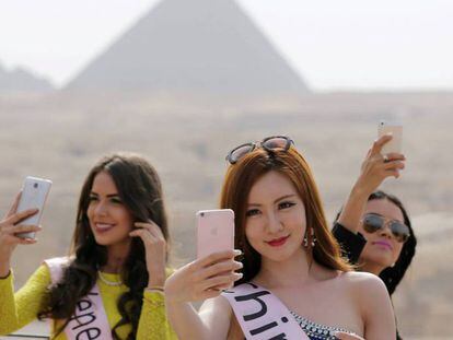 Un grupo de 'misses' se toman selfis frente a las pirámides de Egipto. 