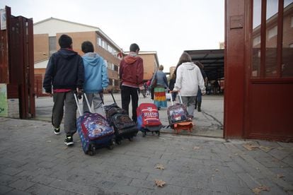 Unos pocos alumnos acceden al interior del Colegio Público La Latina, en Aluche, Madrid, durante la jornada de huelga.