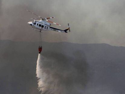 La tripulación de un helicóptero del Infoca vuelve esta mañana a la zona del incendio de Riotinto.