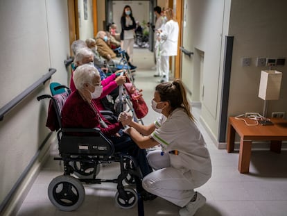 Ancianos de una residencia de mayores en Leganés, Madrid, esperan con sus enfermeras el momento de recibir la vacuna el pasado mes de enero.