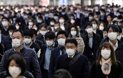 Trabajadores protegidos con mascarillas acuden a sus oficinas en Tokio este lunes