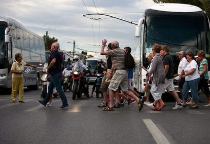 Un grupo de turistas se desplaza a pie por las calles de Atenas.