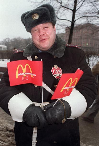 Un guardia muestra banderas con el logo de McDonalds's durante la inauguración del primer establecimiento de la cadena en Moscú en 1990.
