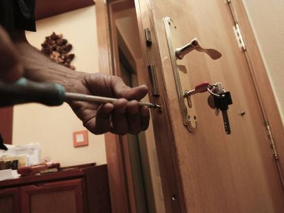 Un cerrajero cambia una cerradura tras el robo a un domicilio.