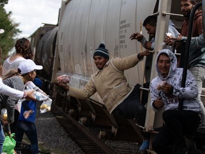 Un grupo de migrantes recibe alimentos a bordo de un tren con rumbo a Eagle Pass (Texas), en la ciudad mexicana de Piedras Negras, en una imagen de archivo.