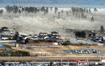 ouses are swept by a tsunami in Natori City in