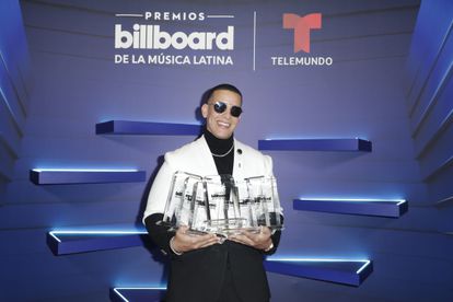 El cantante puertorriqueño Daddy Yankee mientras posa con sus siete Premios Billboard.