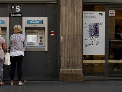 Gente saca dinero en un cajero, en La Rambla de Barcelona.