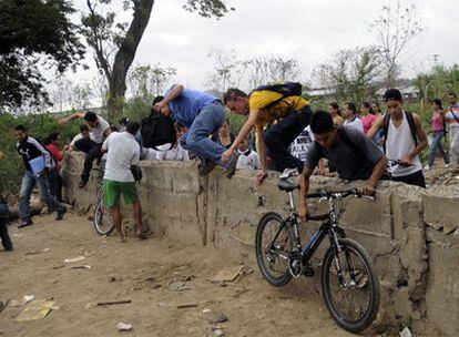 Un grupo de personas salta un muro que separa Colombia de Venezuela.