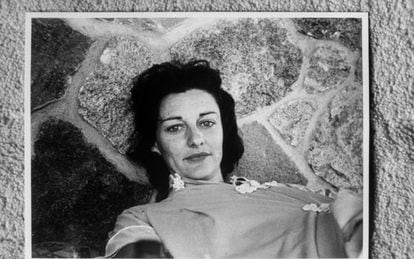 Anne Sexton tumbada en un patio de piedra.