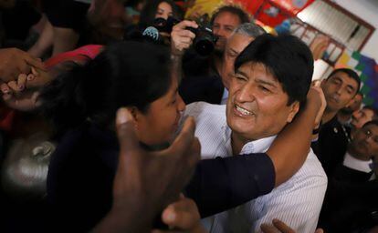 El expresidente de Bolivia, Evo Morales, es recibo por una mujer tras su arribo al aeropuerto de Buenos Aires.