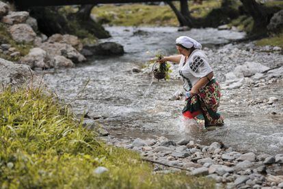 Una mujer cruza un rio realizando un ritual tradicional para que las mujeres solteras de su pueblo encuentren buenos maridos, en Costesti (Rumanía).