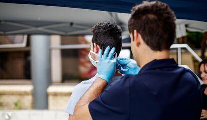 Un paramédico coloca una mascarilla protectora a un visitante recién llegado al hospital Sunninghill de Johanesburgo, Sudáfrica, el 12 de marzo de 2020.