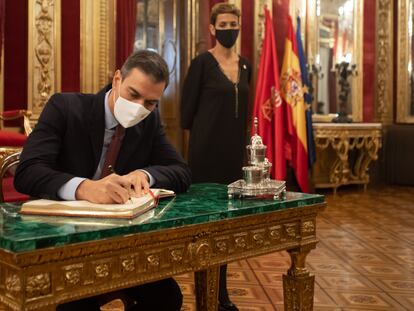 El presidente del Gobierno, Pedro Sánchez, firma en el libro de oro del Gobierno de Navarra ante la presidenta foral María Chivite.