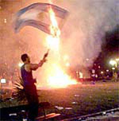 Un manifestante quema una bandera argentina en Buenos Aires.