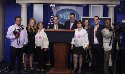 Periodistas cubanos posan ante el atril de prensa de la Casa Blanca