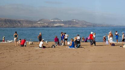 Turistas descansan en una playa.