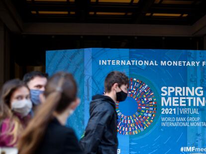 Varios jóvenes pasan ante la sede del FMI en Washington, este lunes.