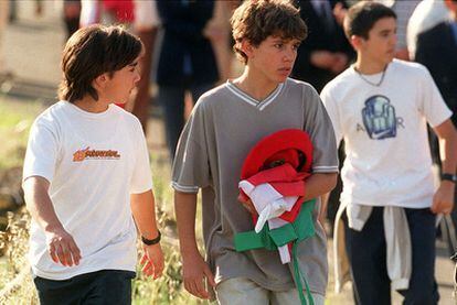 El hijo de Mikel Uribe porta una ikurriña y la boina de su padre, el mando de la Ertzaintza asesinado por ETA en 2001, tras su funeral.