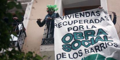 Tres activistas fijan un cartel en el edificio okupado el pasado domingo.