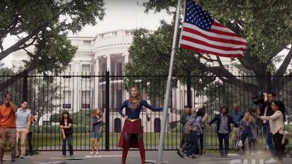 Supergirl con una bandera de EE UU frente a la Casa Blanca.