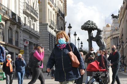 Transeúntes caminan por las inmediaciones de la Puerta del Sol en Madrid, el viernes.