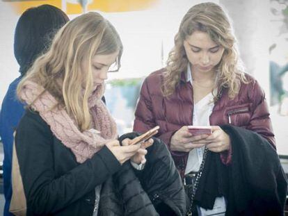 Un grupo de jóvenes reunidos consulta el móvil.