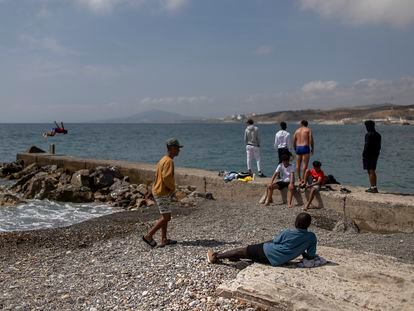 Un grupo de menores, junto a su monitor, en la playa de la Almadraba, en Ceuta, este miércoles.