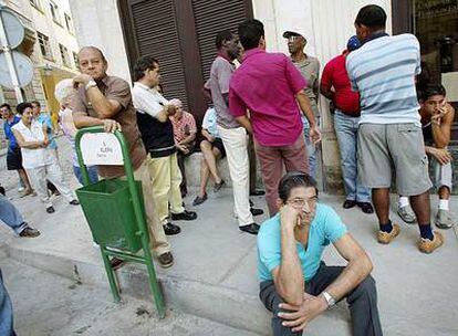 Varias personas esperan ante una oficina de cambio de divisas en La Habana.